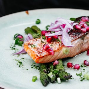 salmon fillet with vegetables on a white plate