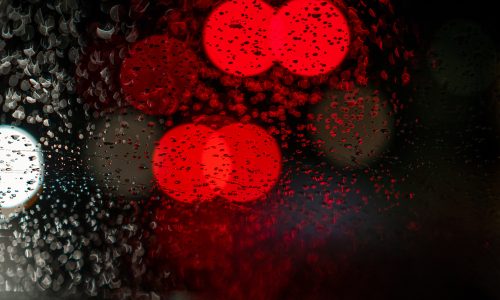 blurry red lights on a rainy window