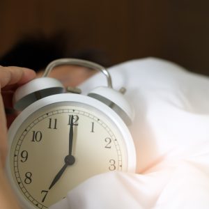 alarm clock on bed sheets