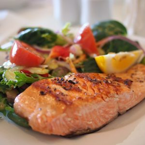 salmon fillet with side salad on white plate