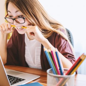 woman stressfully chewing on pencil