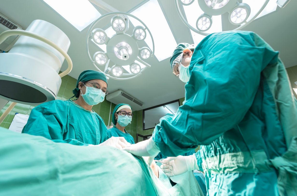 surgeons standing over an operating table