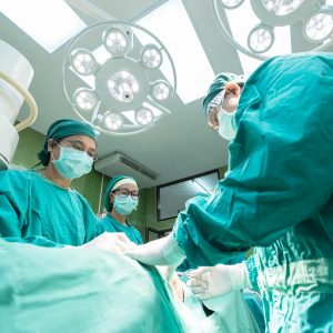 surgeons standing over an operating table