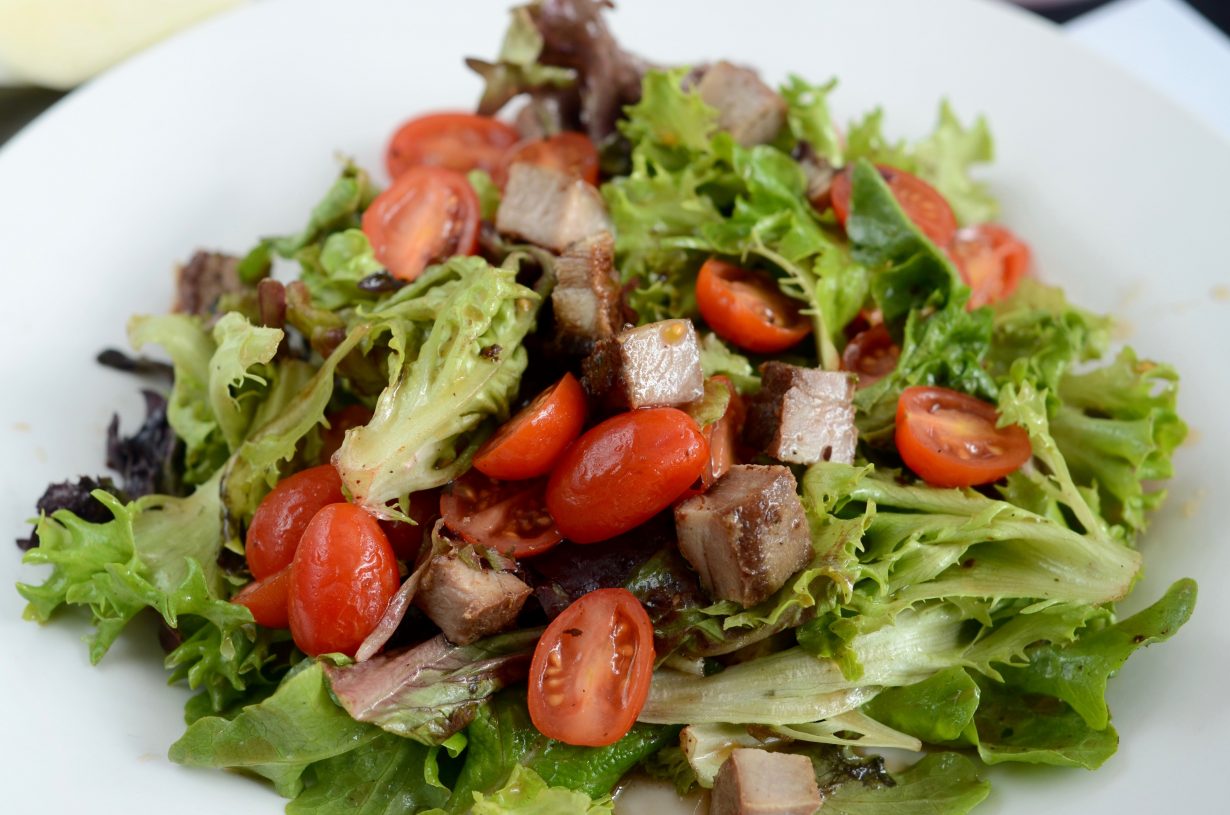 close up of a garden salad with meat and tomatoes