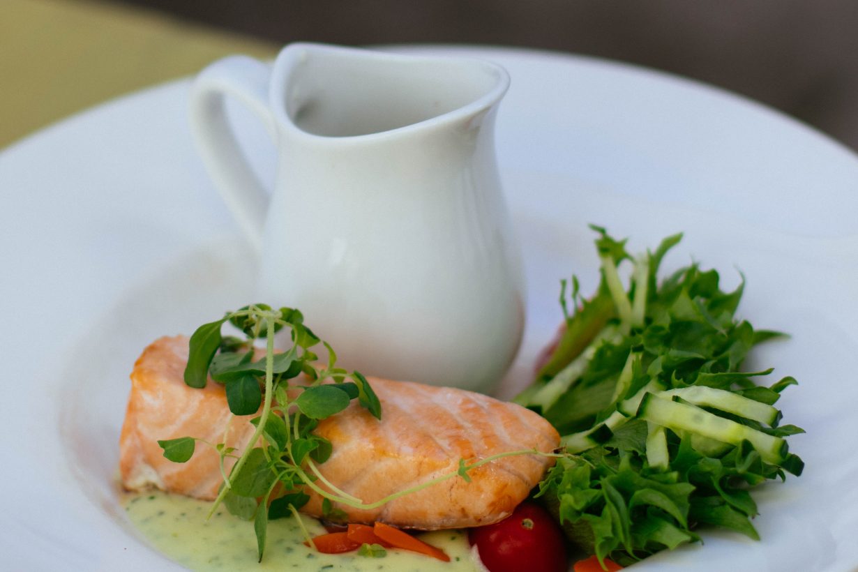 salmon fillet with green salad on a white plate