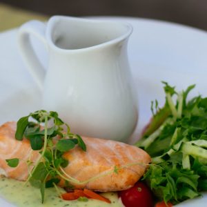 salmon fillet with green salad on a white plate