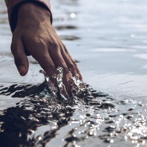 person running their hand over water