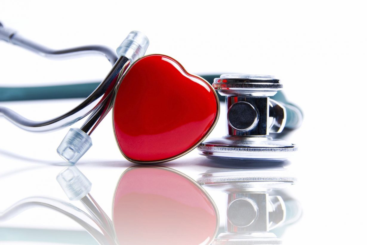 red heart leaning against a stethoscope
