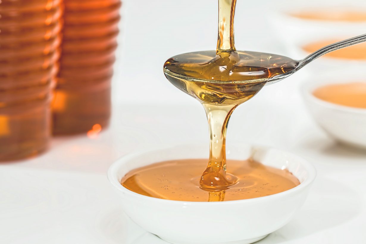 close up of honey being poured on a spoon