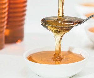 close up of honey being poured on a spoon