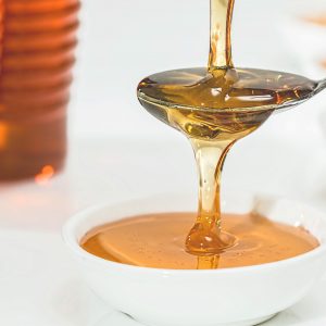 close up of honey being poured on a spoon