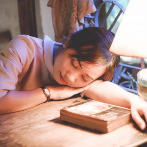 woman asleep with her head slouching on a desk