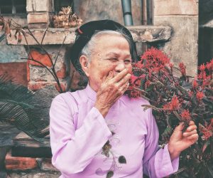old woman laughing with her hand over her mouth