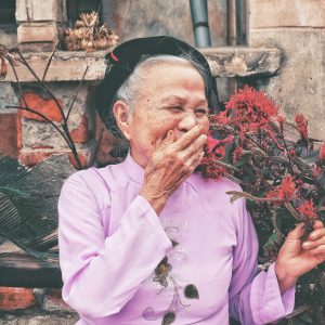 old woman laughing with her hand over her mouth