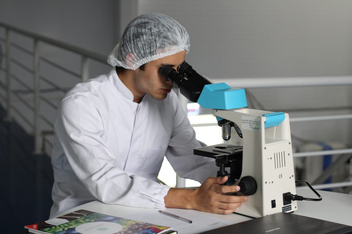 medical researcher looking through a microscope
