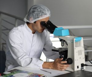 medical researcher looking through a microscope