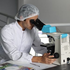 medical researcher looking through a microscope