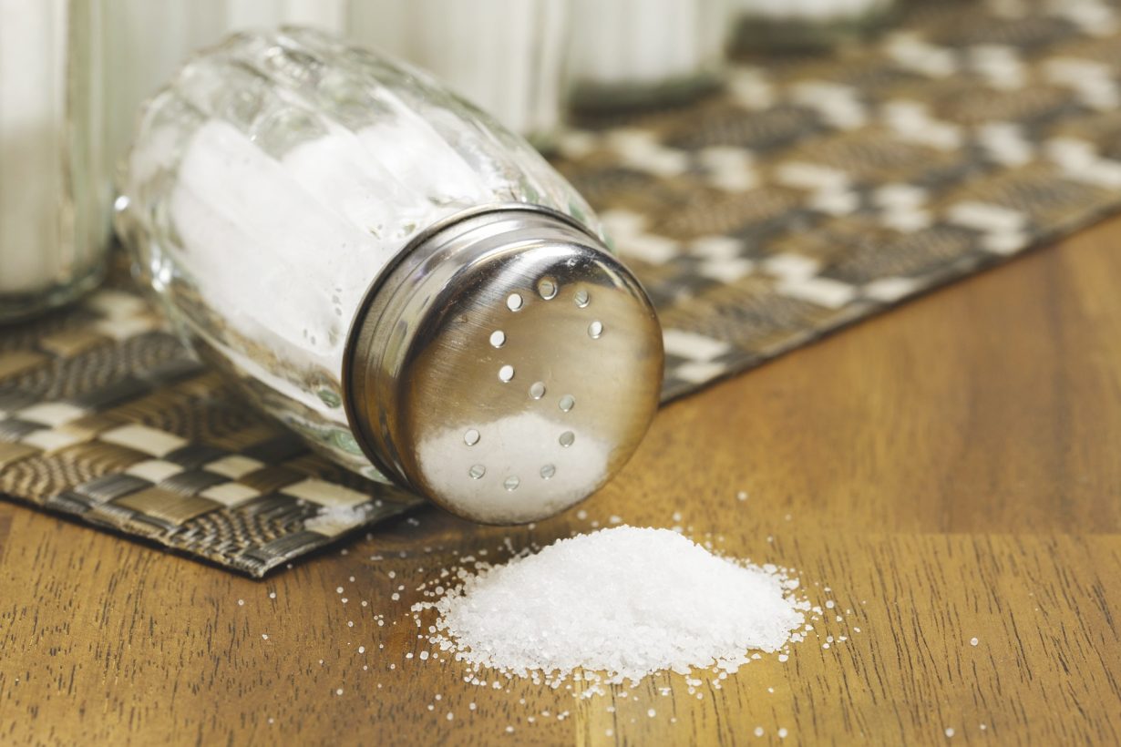 pile of salt in front of a tipped over salt shaker