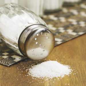 pile of salt in front of a tipped over salt shaker