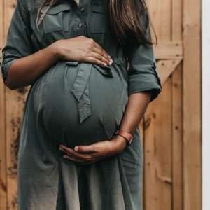 pregnant woman in a dress holding her belly