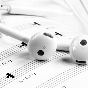 white headphones sitting on sheet music