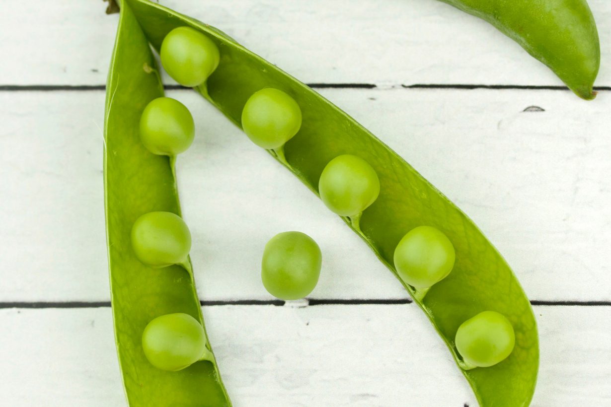 peas in a pod on a white surface