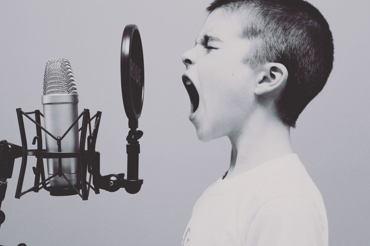 little boy yelling into a pop microphone