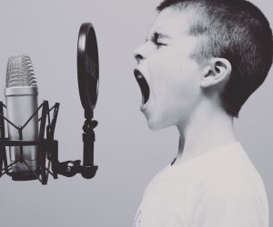 little boy yelling into a pop microphone