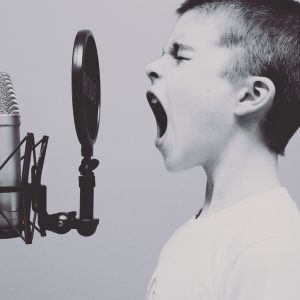 little boy yelling into a pop microphone