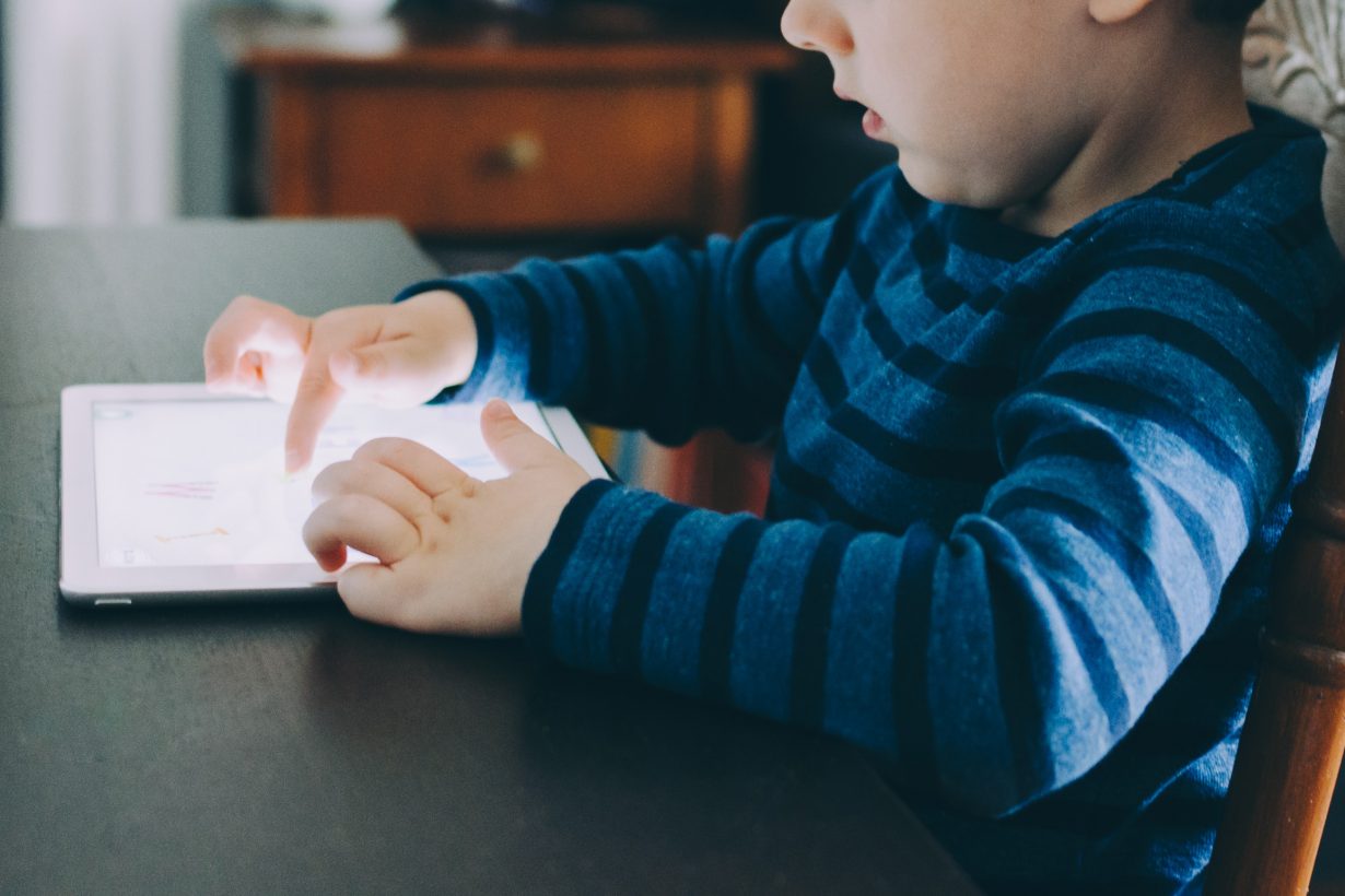 image of a child playing on an iPad