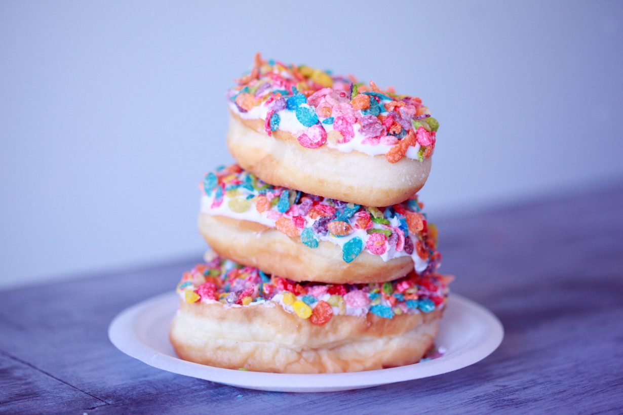 stack of 3 donuts with bright sprinkles on them