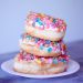stack of 3 donuts with bright sprinkles on them
