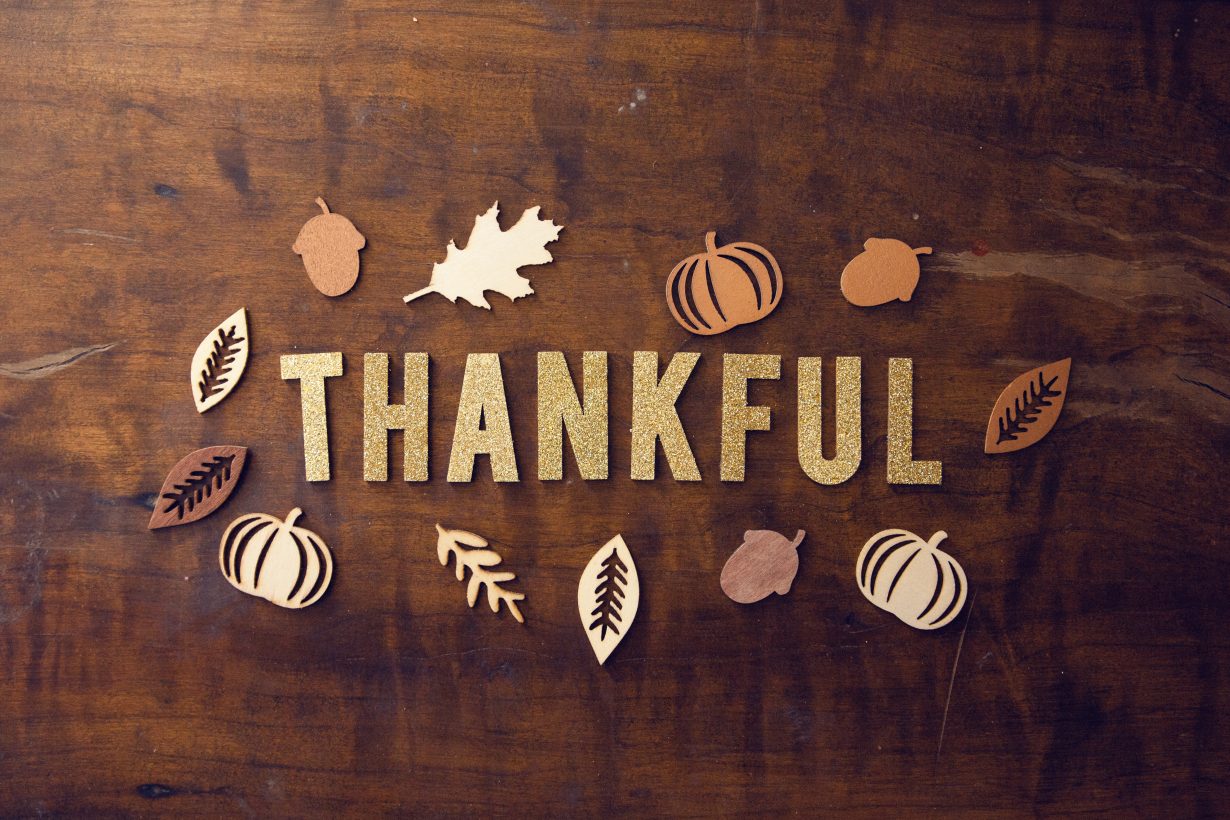 "Thankful" spelled out in letters on a table with leaves around it