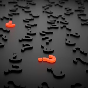 scattered black plastic question marks with a few red ones