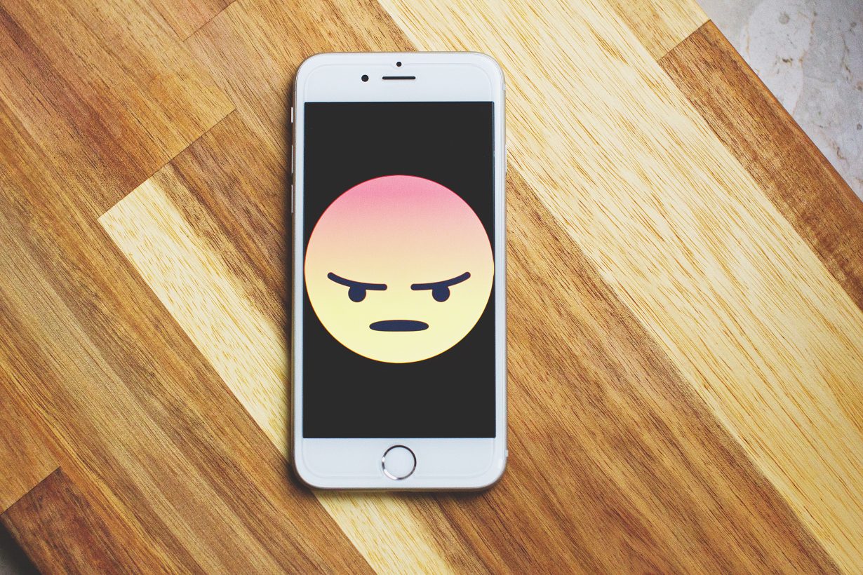 angry face displayed on a cell phone