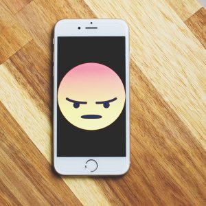 angry face displayed on a cell phone