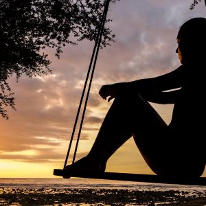 silhouette of a woman sitting on a swing