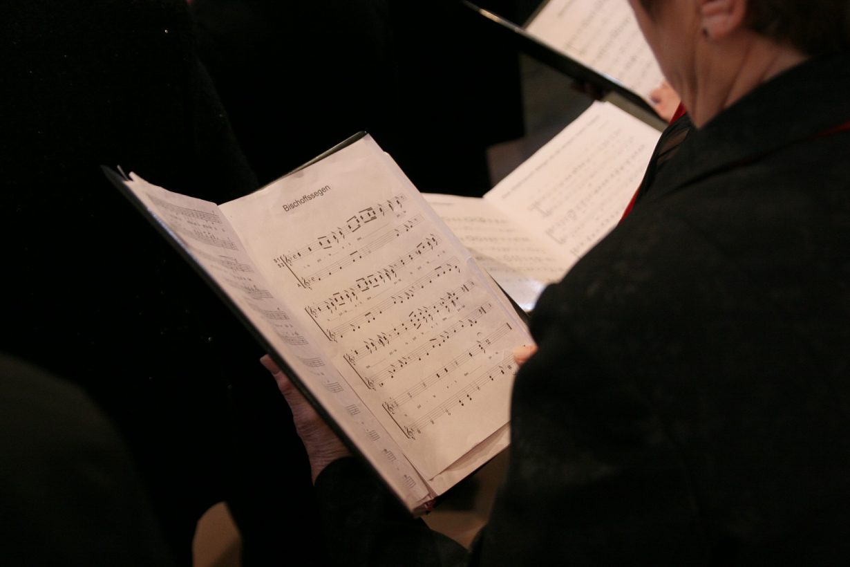 person in a choir holding sheet music