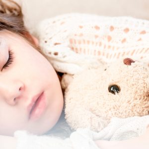 sleeping child holding a stuffed animal