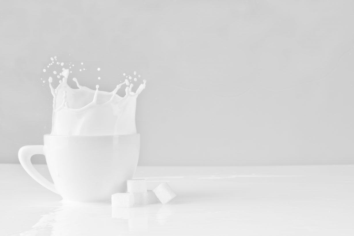 milk splashing out of a white mug