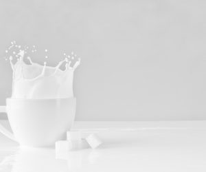 milk splashing out of a white mug