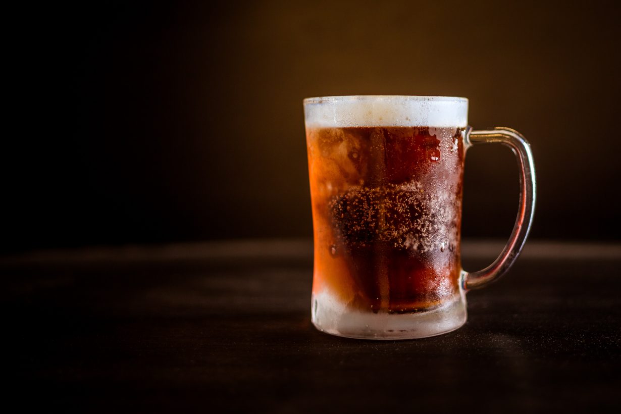 dark beer in a glass stein against a black backdrop