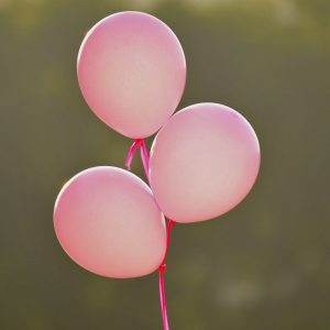3 pink balloons in a bunch, floating