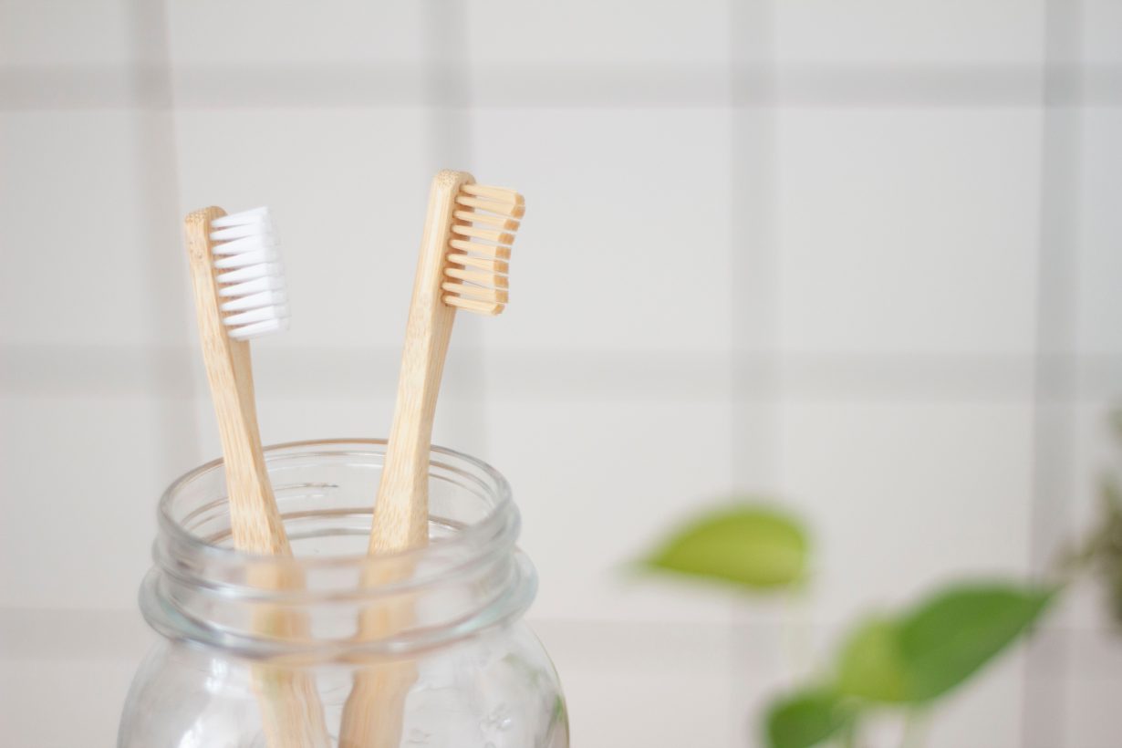 two toothbrushes in a jar