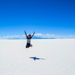 woman jumping up in the air at the salt flats