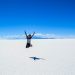woman jumping up in the air at the salt flats