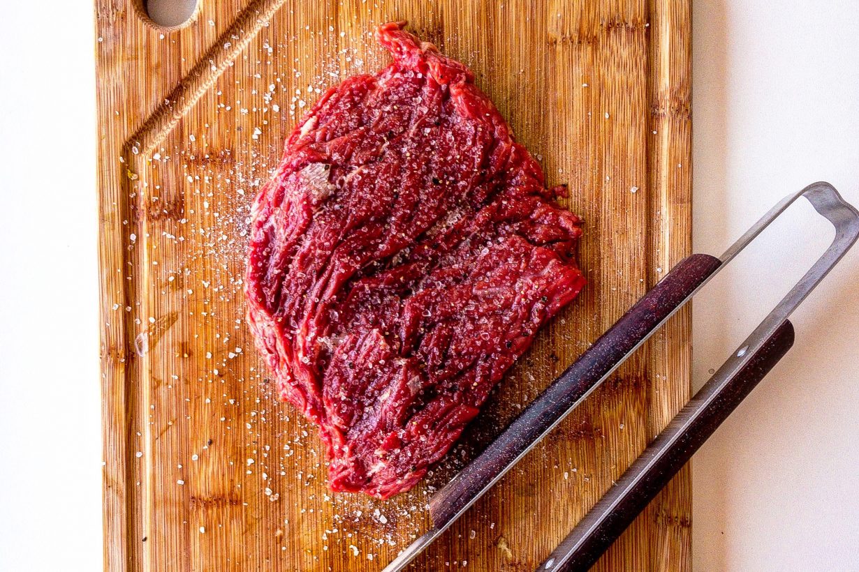 slab of meat covered in salt on a cutting board