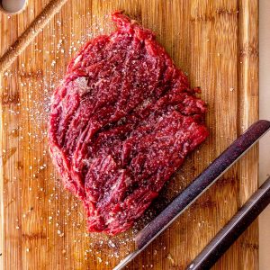 slab of meat covered in salt on a cutting board