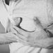 man grasping heart appearing to have a heart attack