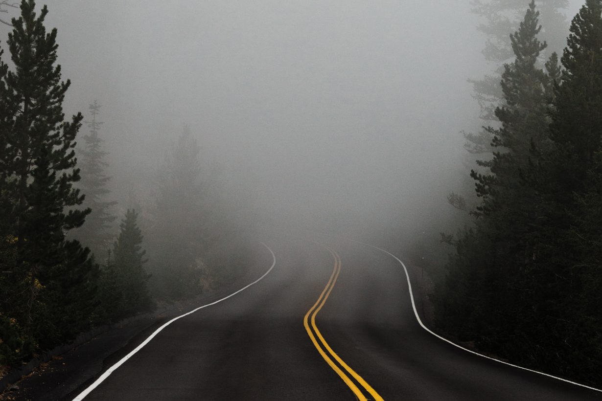 a road with fog in the distance